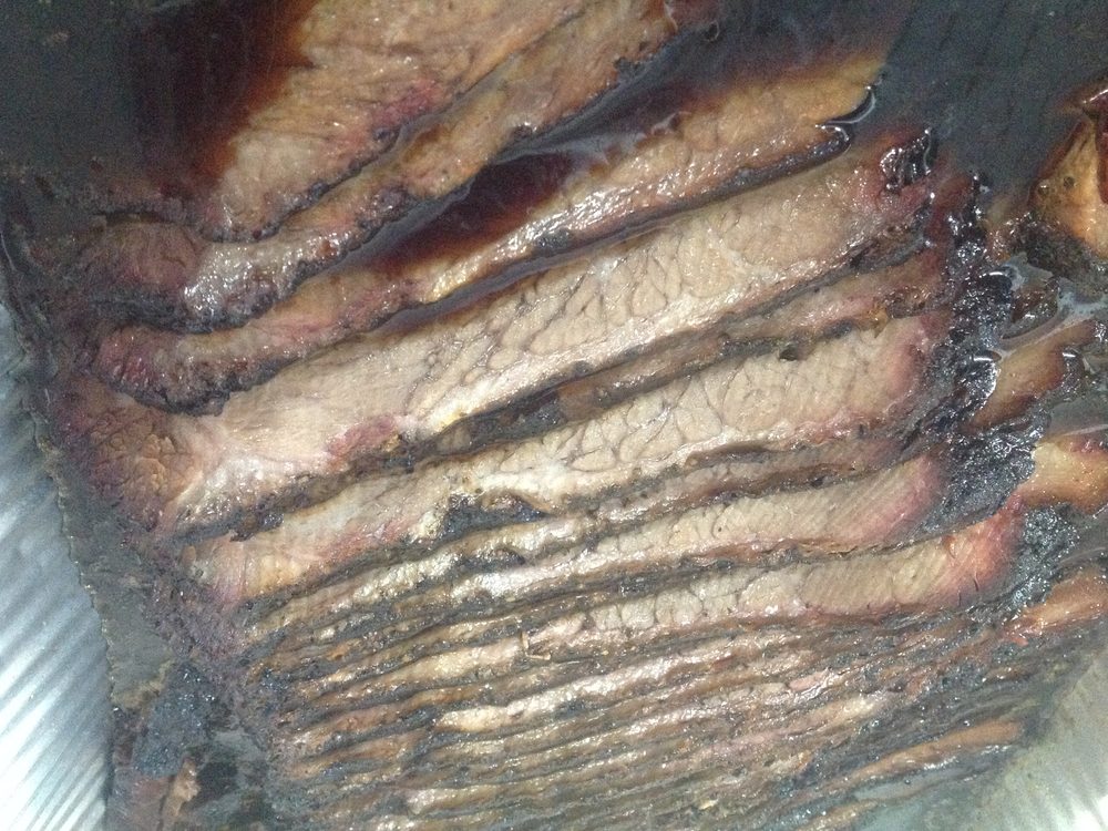 Sliced beef brisket showing the smoke ring and dark bark